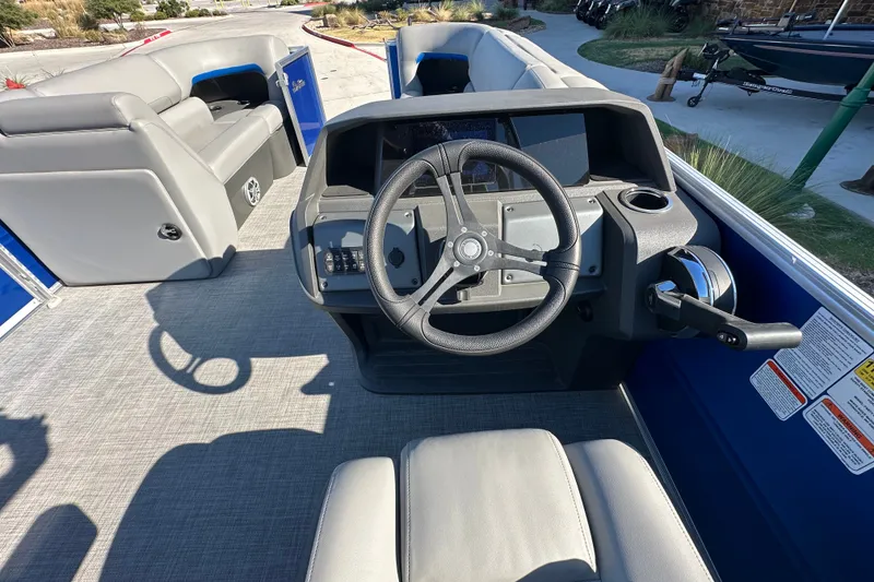 Slide: The Image of 2026 Sun Tracker Party Barge 22 DLX interior with steering wheel and seating. - 48
