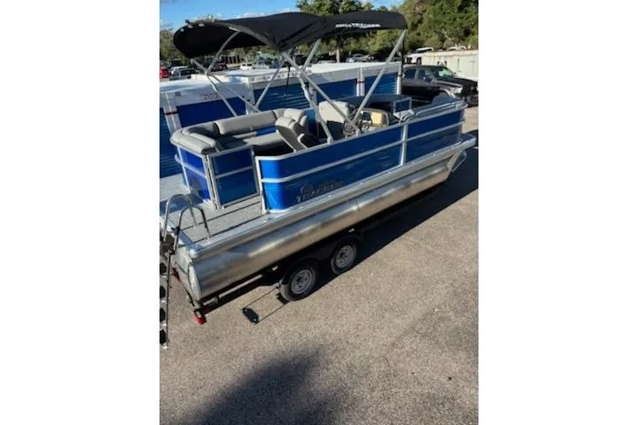 Slide: The Image of 2026 Sun Tracker Party Barge 20 DLX pontoon boat with blue exterior on a trailer. - 3