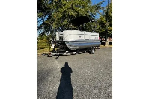 The Image of 2026 Sun Tracker Party Barge 16 DLX pontoon boat on trailer, parked outdoors. - 0