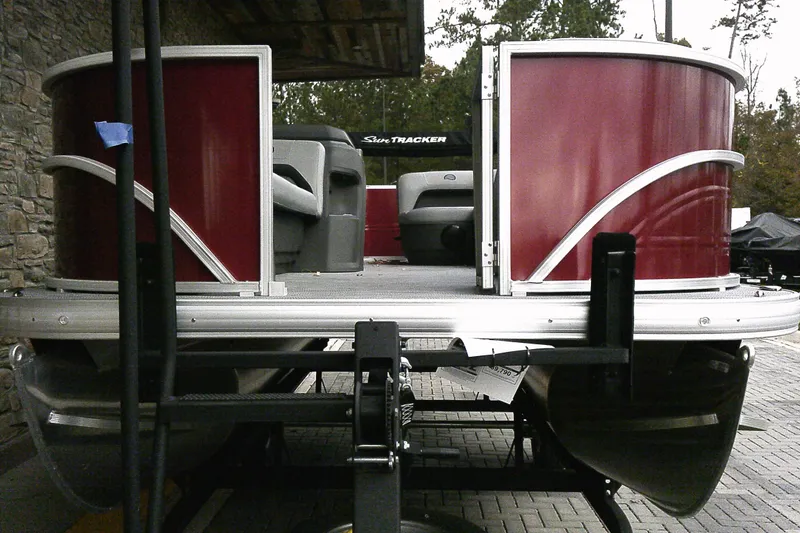 Slide: The Image of 2026 Sun Tracker Party Barge 18 DLX pontoon boat with red exterior on trailer. - 71