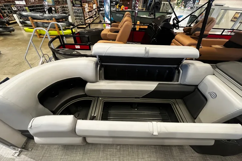Slide: The Image of 2026 Sun Tracker Party Barge 22 DLX interior seating and storage view in showroom. - 102