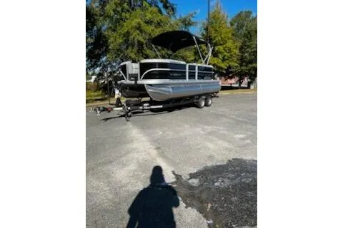 The Image of 2026 Sun Tracker Party Barge 20 DLX pontoon boat parked outdoors. - 0