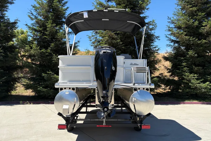 Slide: The Image of 2026 Sun Tracker Party Barge 18 DLX pontoon boat, rear view, parked outdoors. - 9