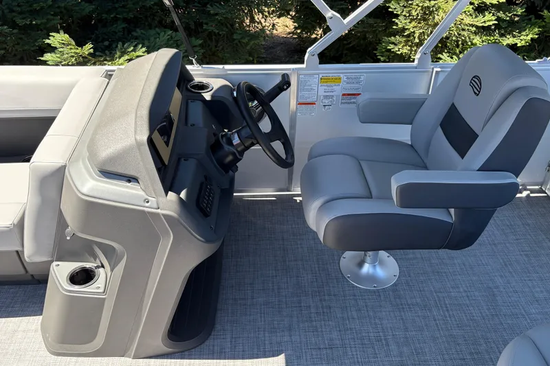 Slide: The Image of 2026 Sun Tracker Party Barge 18 DLX helm with comfortable captain's chair and steering console. - 18