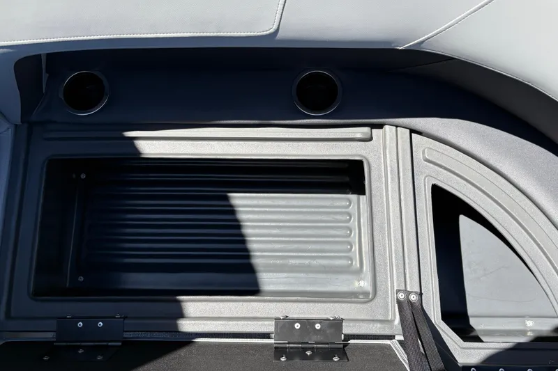 Slide: The Image of Interior detail of 2026 Sun Tracker Party Barge 18 DLX, featuring storage compartment and cup holders. - 31