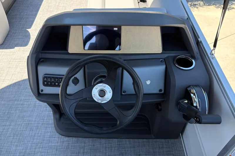 Slide: The Image of 2026 Sun Tracker Party Barge 18 DLX helm with steering wheel and control panel. - 17
