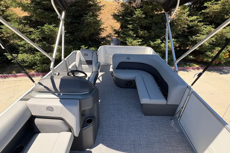 Slide: The Image of 2026 Sun Tracker Party Barge 18 DLX interior with gray seating and steering console. - 15