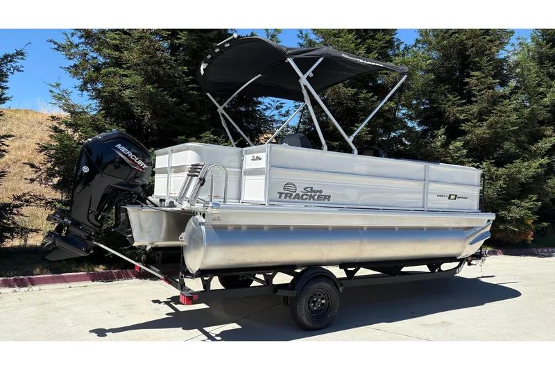 Slide: The Image of 2026 Sun Tracker Party Barge 18 DLX pontoon boat on trailer, parked outdoors. - 4