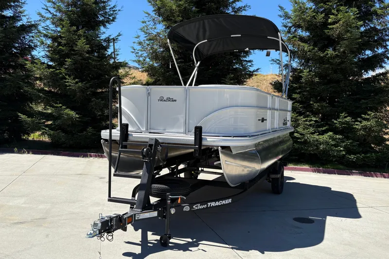 Slide: The Image of 2026 Sun Tracker Party Barge 18 DLX pontoon boat on trailer, parked outdoors. - 8