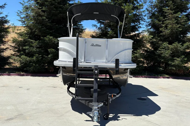 Slide: The Image of 2026 Sun Tracker Party Barge 18 DLX pontoon boat on trailer, parked outdoors. - 7