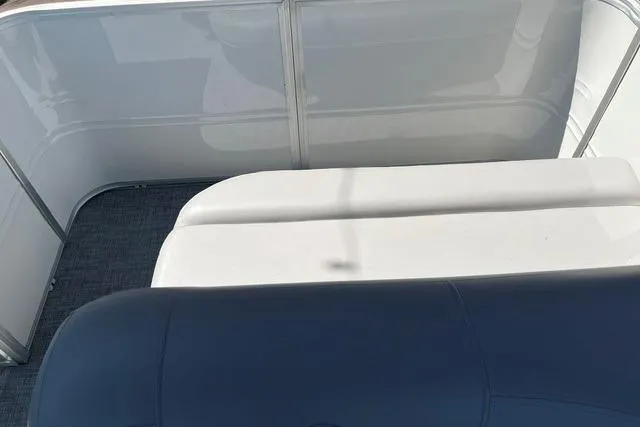 Slide: The Image of 2026 Sun Tracker Party Barge 18 DLX interior seating with white and navy cushions. - 4