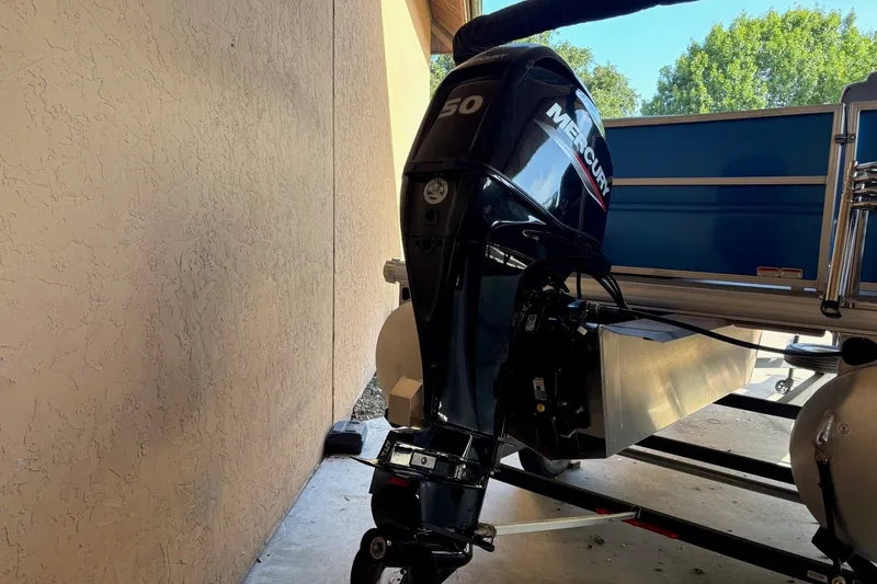 Slide: The Image of 2026 Sun Tracker Party Barge 16 DLX with Mercury 50 outboard motor in a garage. - 10