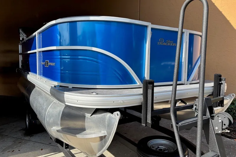 Slide: The Image of 2026 Sun Tracker Party Barge 16 DLX pontoon boat in vibrant blue on trailer. - 12