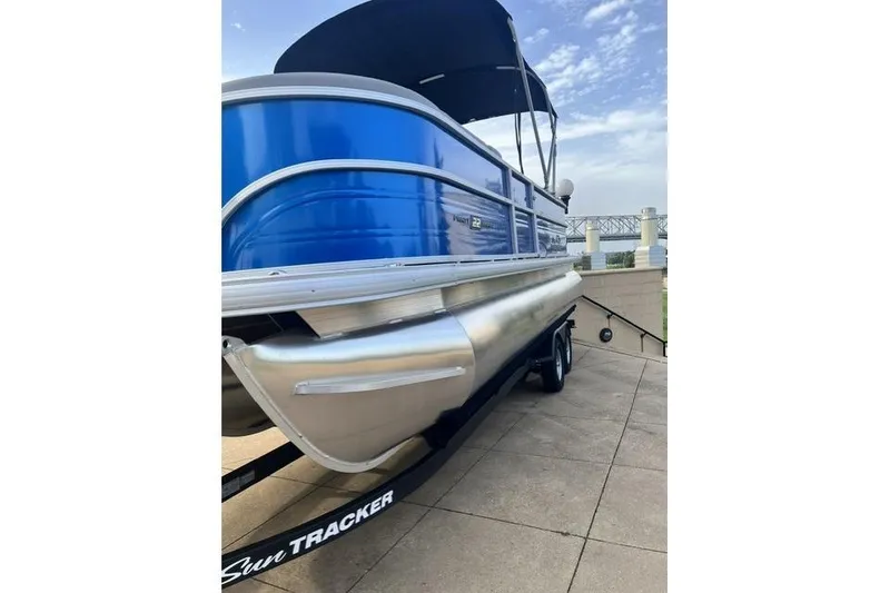 Slide: The Image of 2026 Sun Tracker Party Barge 22 XP3 pontoon boat on trailer, blue exterior. - 3