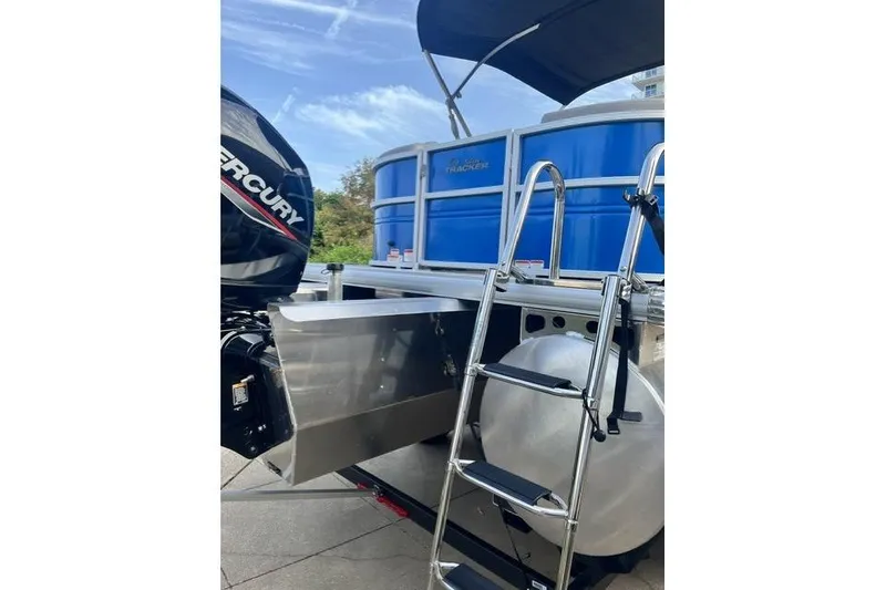 Slide: The Image of 2026 Sun Tracker Party Barge 22 XP3 with Mercury engine and ladder, docked outdoors. - 11