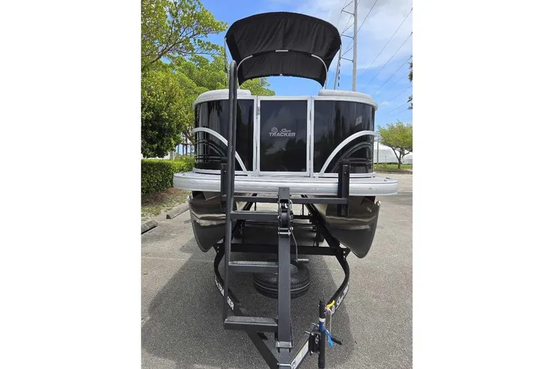 Slide: The Image of 2026 Sun Tracker Party Barge 22 DLX pontoon boat on trailer, parked outdoors. - 6