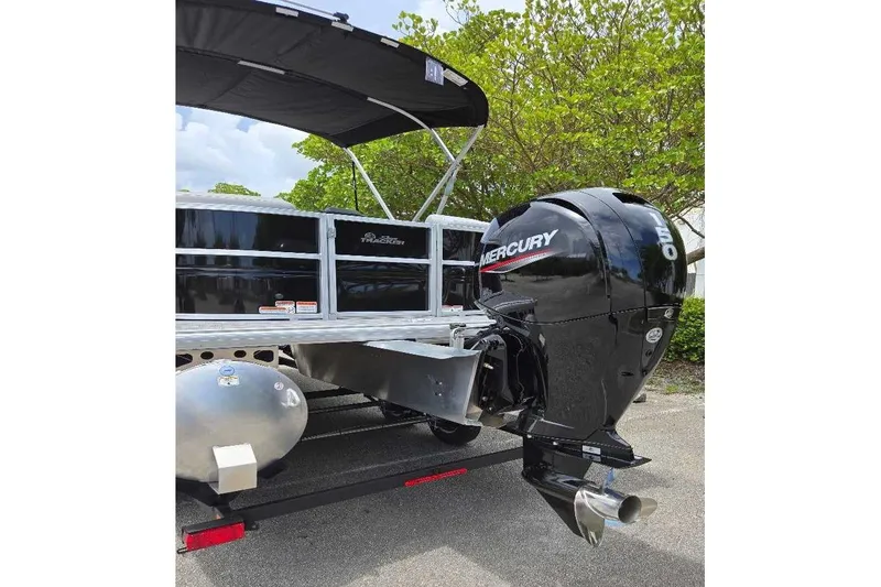 Slide: The Image of 2026 Sun Tracker Party Barge 22 DLX with Mercury outboard motor, parked outdoors. - 7