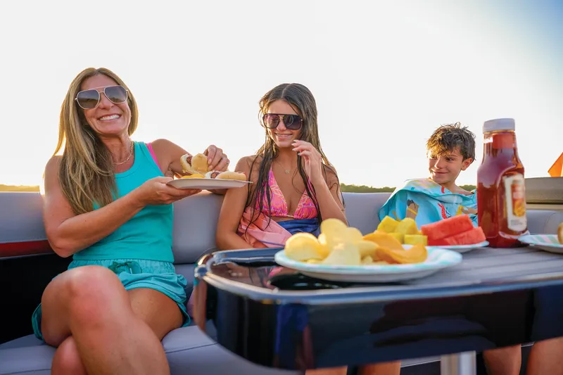 Slide: The Image of 2026 Sun Tracker Party Barge 22 DLX interior seating with storage compartments open. - 13