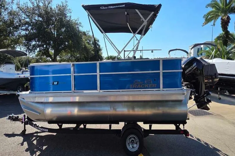 Slide: The Image of 2026 Sun Tracker Party Barge 18 DLX pontoon boat on trailer, parked outdoors. - 3