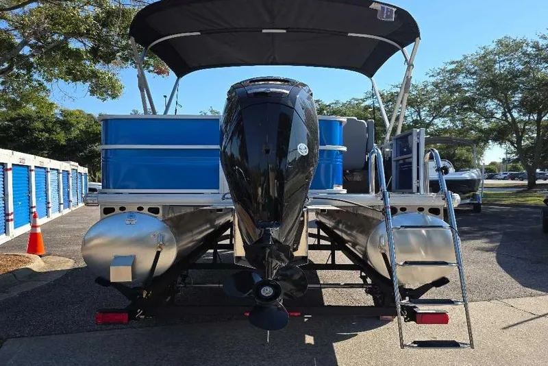 Slide: The Image of 2026 Sun Tracker Party Barge 18 DLX pontoon boat, rear view with motor and ladder. - 4