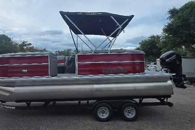 Slide: The Image of 2026 Sun Tracker Party Barge 20 DLX pontoon boat with canopy on trailer. - 2