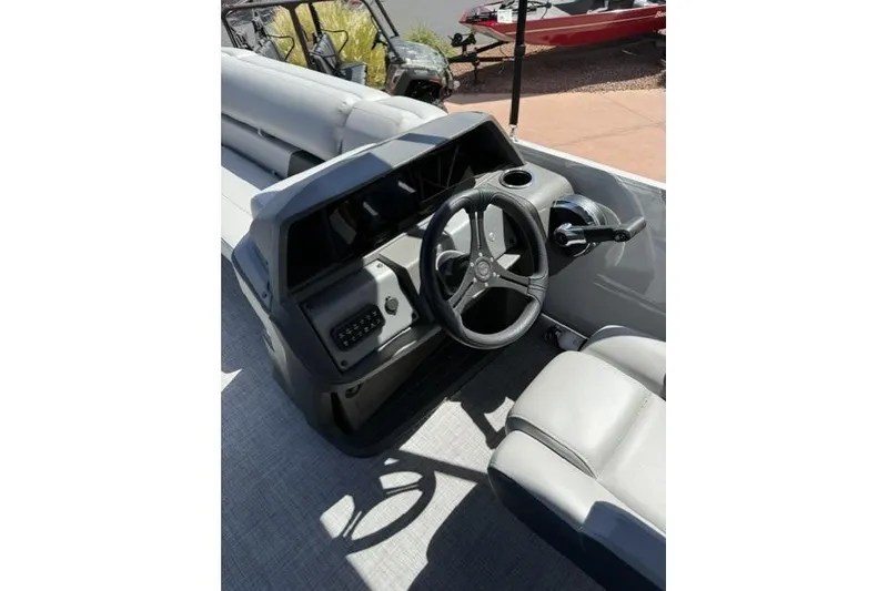 Slide: The Image of 2026 Sun Tracker Party Barge 20 DLX steering console with modern controls and seating. - 4