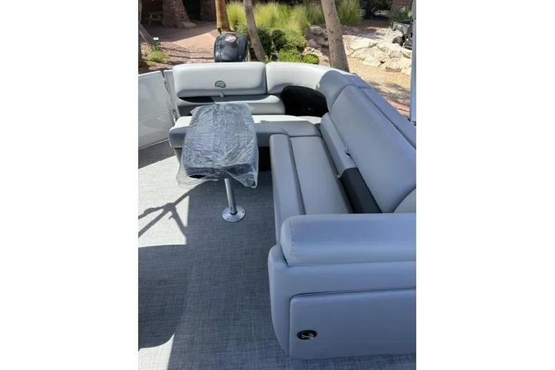 Slide: The Image of 2026 Sun Tracker Party Barge 20 DLX interior with gray seating and table. - 7