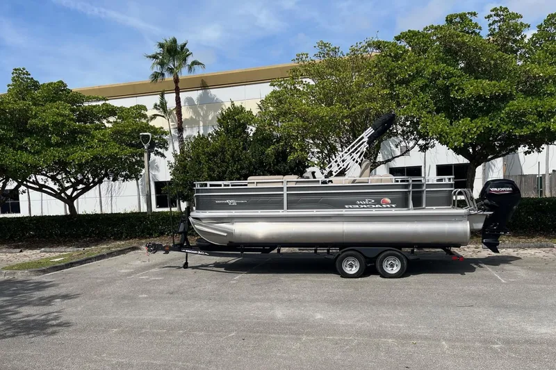 The Image of 2026 Sun Tracker Party Barge 16 DLX pontoon boat parked outdoors. - 0