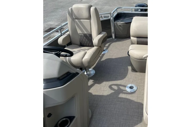 Slide: The Image of 2026 Sun Tracker Party Barge 16 DLX interior with beige seating and steering console. - 10