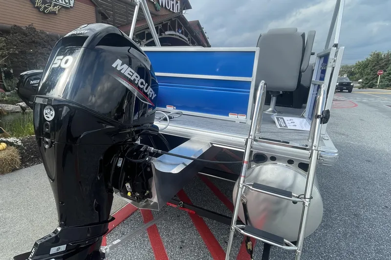 Slide: The Image of 2026 Sun Tracker Party Barge 16 DLX with spacious seating and modern design in a parking lot. - 2