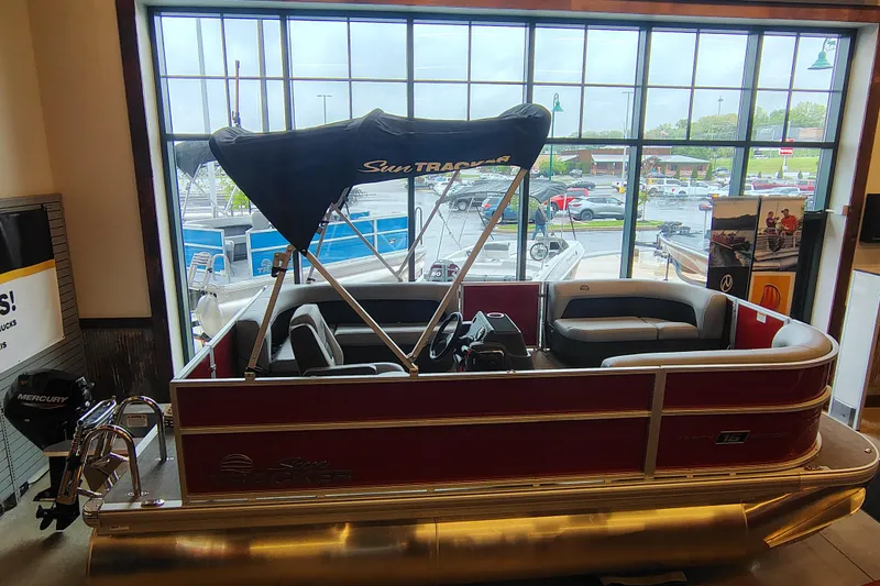 The Image of 2026 Sun Tracker Party Barge 16 DLX pontoon boat displayed indoors. - 0