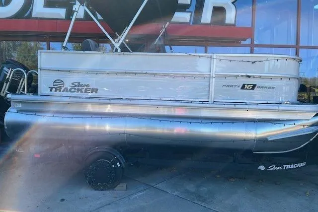 The Image of 2026 Sun Tracker Party Barge 16 DLX pontoon boat displayed outdoors. - 0