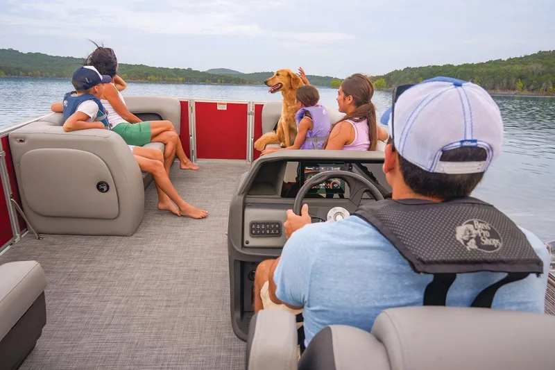 Slide: The Image of 2026 Sun Tracker Party Barge 18 DLX storage compartment with open seat and red interior. - 8