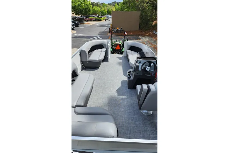 Slide: The Image of 2026 Sun Tracker Party Barge 16 DLX interior with gray seating and steering console. - 8