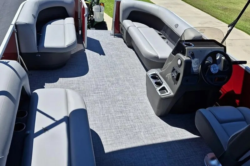 Slide: The Image of 2026 Sun Tracker Party Barge 16 DLX interior with gray seating and steering console. - 3