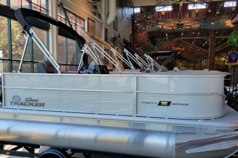 The Image of 2026 Sun Tracker Party Barge 16 DLX pontoon boat displayed indoors. - 0