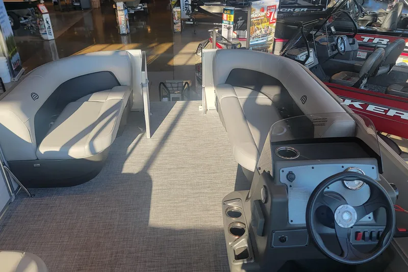 Slide: The Image of 2026 Sun Tracker Party Barge 16 DLX interior with seating and steering console. - 2