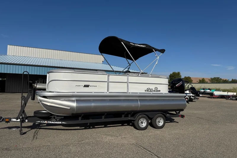 The Image of 2026 Sun Tracker Party Barge 20 DLX pontoon boat on trailer, outdoor setting. - 0