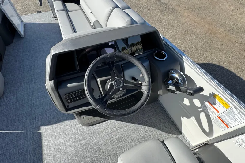 Slide: The Image of 2026 Sun Tracker Party Barge 20 DLX steering console with modern controls and seating. - 11