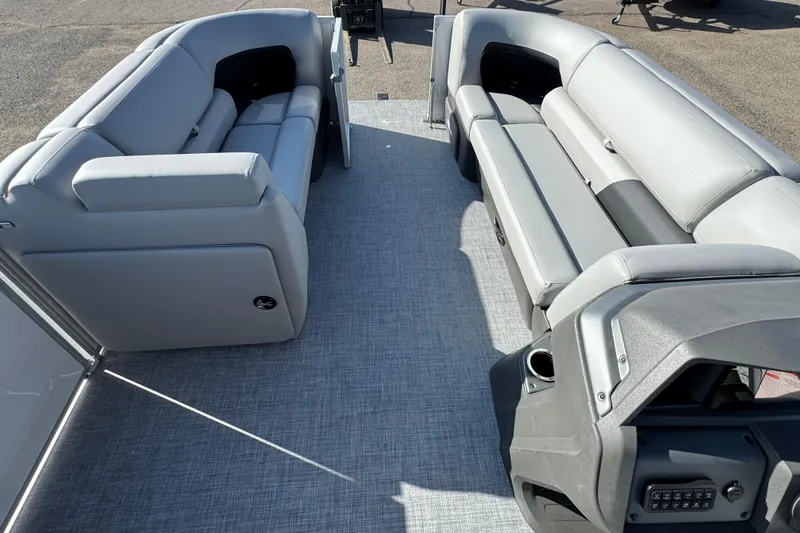 Slide: The Image of 2026 Sun Tracker Party Barge 20 DLX interior with gray seating and control panel. - 12