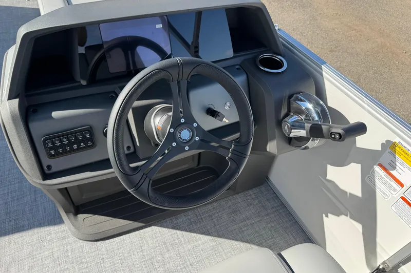 Slide: The Image of 2026 Sun Tracker Party Barge 20 DLX steering console with controls and cup holder. - 14