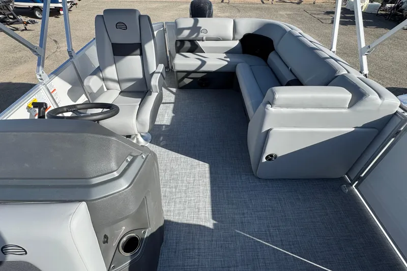 Slide: The Image of 2026 Sun Tracker Party Barge 20 DLX interior with gray seating and steering console. - 9