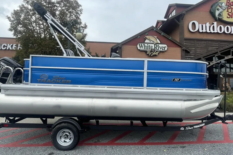 The Image of 2026 Sun Tracker Party Barge 18 DLX pontoon boat displayed outside outdoor shop. - 0