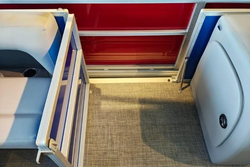 Slide: The Image of Interior view of 2026 Sun Tracker Party Barge 18 DLX, featuring seating and red paneling. - 7