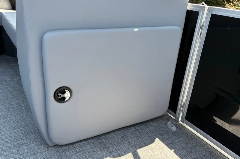Slide: The Image of 2026 Sun Tracker Party Barge 20 DLX interior detail with gray upholstery and storage compartment. - 38