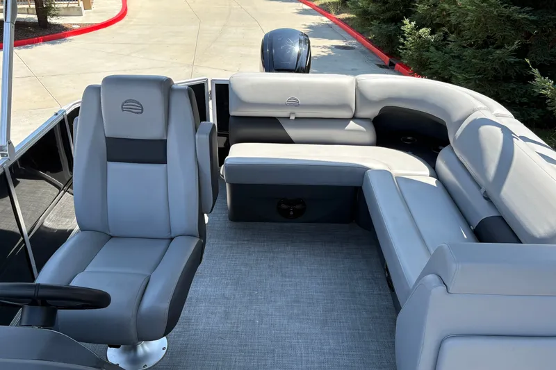 Slide: The Image of 2026 Sun Tracker Party Barge 20 DLX interior with gray seating and steering area. - 30