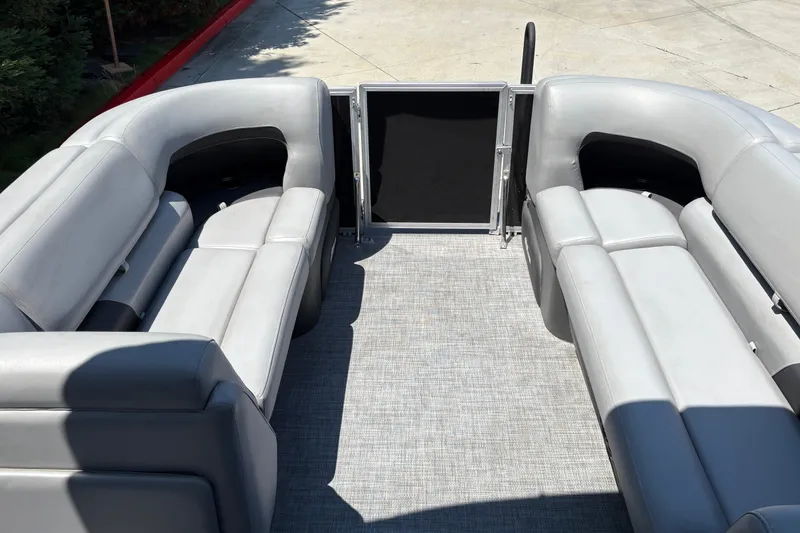 Slide: The Image of 2026 Sun Tracker Party Barge 20 DLX interior with gray seating and open gate. - 16