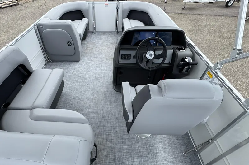 Slide: The Image of 2026 Sun Tracker Party Barge 16 DLX interior with gray seating and steering console. - 10