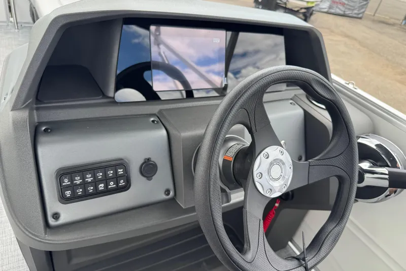 Slide: The Image of 2026 Sun Tracker Party Barge 16 DLX dashboard with steering wheel and control panel. - 12