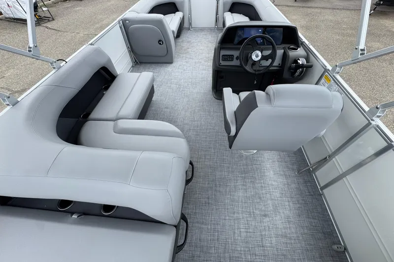 Slide: The Image of 2026 Sun Tracker Party Barge 16 DLX interior with gray seating and steering console. - 15